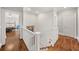 Upstairs hallway with hardwood floors, white trim, and an open doorway into a bedroom at 1904 Woodland Hills Nw Ave, Atlanta, GA 30318
