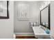 Classic powder room featuring a pedestal sink, framed mirror, and window with plantation shutters at 1904 Woodland Hills Nw Ave, Atlanta, GA 30318