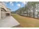 Expansive backyard featuring a concrete patio, lush lawn, and tall trees, perfect for outdoor enjoyment and relaxation at 3365 Preservation Cir, Lilburn, GA 30047