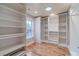 Large walk-in closet with custom shelving and hardwood floors at 3365 Preservation Cir, Lilburn, GA 30047