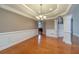 Formal dining room featuring tray ceiling, elegant wainscoting, and hardwood floors at 3365 Preservation Cir, Lilburn, GA 30047