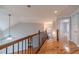 Upstairs landing featuring hardwood floors, wood railing, and staircase at 3365 Preservation Cir, Lilburn, GA 30047