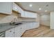 Basement kitchenette featuring granite counters, white cabinetry, recessed lighting, and hardwood floors at 3365 Preservation Cir, Lilburn, GA 30047