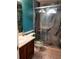 Bathroom featuring granite tiled shower with glass doors, teal accent wall, and wooden vanity at 1034 Bettina Ct, Mableton, GA 30126