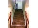 Carpeted stairs with a wooden handrail lead to the upper level with light green colored walls at 1034 Bettina Ct, Mableton, GA 30126