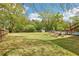 Large backyard featuring a fence, green grass, trees, garden plots, shed, and swimming pool at 105 Oakfield Way, Douglasville, GA 30134