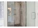 Walk-in shower with stone floor, shower head, glass door, and bathroom vanity at 105 Oakfield Way, Douglasville, GA 30134