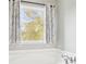 Bathroom with tub and a view from the window with light and patterned curtains at 105 Oakfield Way, Douglasville, GA 30134