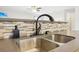 Kitchen sink with stainless steel basin, gray countertop, and decorative tile backsplash at 105 Oakfield Way, Douglasville, GA 30134