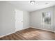 Bedroom featuring modern flooring, a window with blinds, and a white door at 109 Beaver Dam Rd, Peachtree City, GA 30269