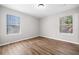 A bedroom featuring modern flooring and dual windows with blinds at 109 Beaver Dam Rd, Peachtree City, GA 30269