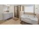 Bathroom featuring a soaking tub, glass-enclosed shower, and vanity at 3048 Level Grove Ln, Dacula, GA 30019
