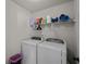 Efficient laundry room with modern washer and dryer units, plus shelving for supplies at 3048 Level Grove Ln, Dacula, GA 30019