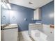 Blue bathroom features a tub, granite countertops, a white vanity and white cabinets at 4186 Argonne Dr, Villa Rica, GA 30180