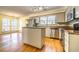 Open kitchen with stainless appliances, island, wood floors, and light wood cabinets at 4186 Argonne Dr, Villa Rica, GA 30180