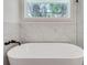 Modern bathtub with sleek fixtures and marble tile surround at 1861 Dyer Cir, Atlanta, GA 30341