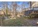 View of the grassy backyard with a stone retaining wall and stairs leading to the upper deck at 4519 Glenforest Ne Dr, Roswell, GA 30075