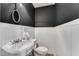 Powder room featuring black walls, wainscoting, and a sleek pedestal sink at 4519 Glenforest Ne Dr, Roswell, GA 30075