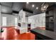 Modern game room with red floors, featuring a built in table/bar with a ping pong net, storage shelves, and a fireplace at 4519 Glenforest Ne Dr, Roswell, GA 30075
