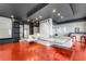 Wide angle shot of a game room with red floors, modern lighting, a ping pong table/bar with built in seating, and shelving at 4519 Glenforest Ne Dr, Roswell, GA 30075