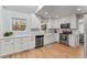 Stylish kitchen with white cabinets, stainless steel appliances, farmhouse sink, and modern backsplash at 4519 Glenforest Ne Dr, Roswell, GA 30075