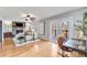 Open living room with a stone fireplace, hardwood floors, and French doors to a deck with wooded views at 4519 Glenforest Ne Dr, Roswell, GA 30075