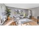 Cozy living room featuring hardwood floors, a grey sofa, two chairs, and a sun-filled window with views of the outdoors at 4519 Glenforest Ne Dr, Roswell, GA 30075
