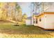 Backyard view of the home with a spacious lawn, landscaping and yellow vinyl siding at 531 Lindsey Way, Social Circle, GA 30025
