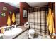 Bathroom features a single sink vanity, toilet, shower with curtain and burgundy colored walls at 531 Lindsey Way, Social Circle, GA 30025