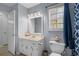 A clean bathroom with a sink and vanity cabinet, mirror and commode with a blue shower curtain at 615 Upland Nw Trl, Conyers, GA 30012