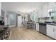 Well-lit kitchen with stainless steel appliances, granite countertops, white cabinets, and laminate flooring at 615 Upland Nw Trl, Conyers, GA 30012