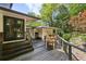 The back yard's wooden deck has an outdoor dining set and bridge to another portion of the house at 240 W Spalding Dr, Sandy Springs, GA 30328