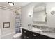 Bathroom features a shower-tub combo, a granite countertop vanity, modern fixtures, and sleek lighting at 240 W Spalding Dr, Sandy Springs, GA 30328