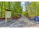 Paved community pathway with signage for garden beds, nestled among lush greenery and mature trees at 240 W Spalding Dr, Sandy Springs, GA 30328