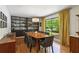 Elegant dining room featuring modern lighting, hardwood floors, and a large window overlooking the yard at 240 W Spalding Dr, Sandy Springs, GA 30328