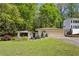 Charming ranch-style home with attached garage, landscaped yard, and inviting entrance nestled among mature trees at 240 W Spalding Dr, Sandy Springs, GA 30328