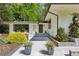 Modern home with updated landscaping and a sleek entryway design with an outdoor sitting area at 240 W Spalding Dr, Sandy Springs, GA 30328
