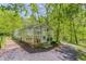 Glass greenhouse surrounded by lush greenery and mature trees, perfect for gardening enthusiasts at 240 W Spalding Dr, Sandy Springs, GA 30328