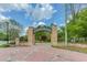Stone entrance to Abernathy Greenway with brick walkway and landscaped surroundings, framed by blue skies at 240 W Spalding Dr, Sandy Springs, GA 30328