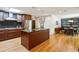 Stylish kitchen with cherry cabinets, a center island with seating, and seamless flow into the dining area at 240 W Spalding Dr, Sandy Springs, GA 30328