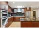 Modern kitchen featuring cherry cabinets, stainless steel appliances, granite countertops, and a skylight at 240 W Spalding Dr, Sandy Springs, GA 30328
