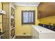 Functional laundry room with washer, dryer, shelving, and storage cabinets for household cleaning supplies at 240 W Spalding Dr, Sandy Springs, GA 30328