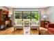 Open living area boasts hardwood floors, large windows with a scenic view, and a cozy seating arrangement at 240 W Spalding Dr, Sandy Springs, GA 30328