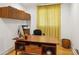 Bright home office space featuring a wooden desk, shelving, and natural light from patterned curtains at 240 W Spalding Dr, Sandy Springs, GA 30328