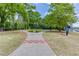 Scenic park view featuring paved walkways, sculptures, mature trees, and well-maintained grassy areas on a sunny day at 240 W Spalding Dr, Sandy Springs, GA 30328