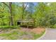 Wooden pavilion with picnic tables surrounded by lush greenery and mature trees, offering a shaded outdoor space at 240 W Spalding Dr, Sandy Springs, GA 30328
