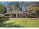Charming single-story home with a well-manicured lawn, a red front door and a covered front porch at 2992 Westminster Nw Cir, Atlanta, GA 30327