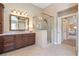 Modern bathroom with a glass shower, dark cabinetry, a large mirror, and a doorway view to bedroom at 3225 Suffolk Dr, Cumming, GA 30041