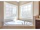Bright bathroom featuring a soaking tub under two large windows, providing a spa-like atmosphere at 3225 Suffolk Dr, Cumming, GA 30041
