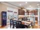 Well-lit dining area with wine storage flows into a kitchen with dark wood cabinets and island at 3225 Suffolk Dr, Cumming, GA 30041